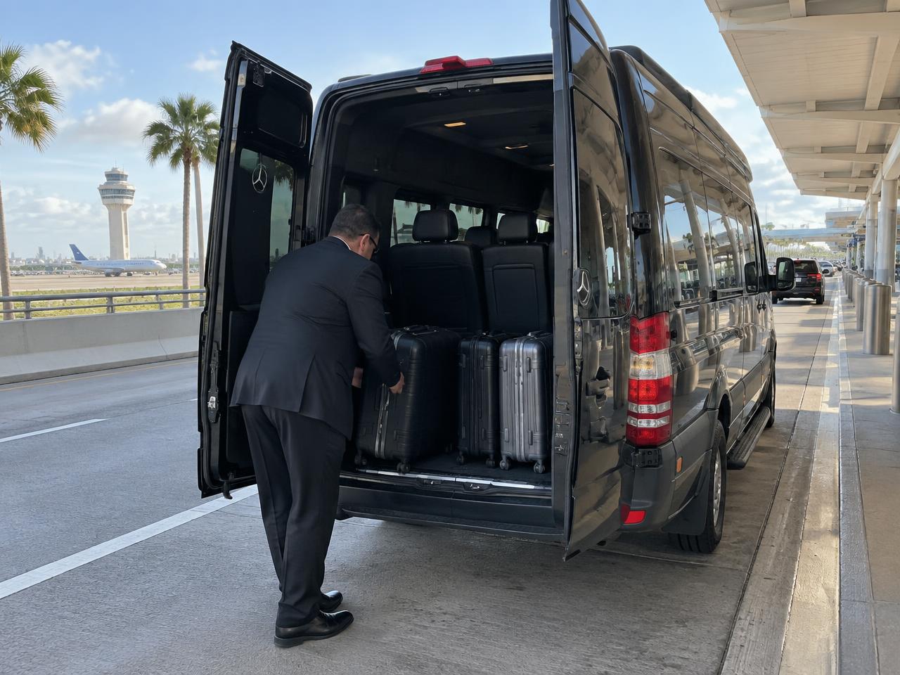 Chauffeur loading luggage into the Sprinter at the airport