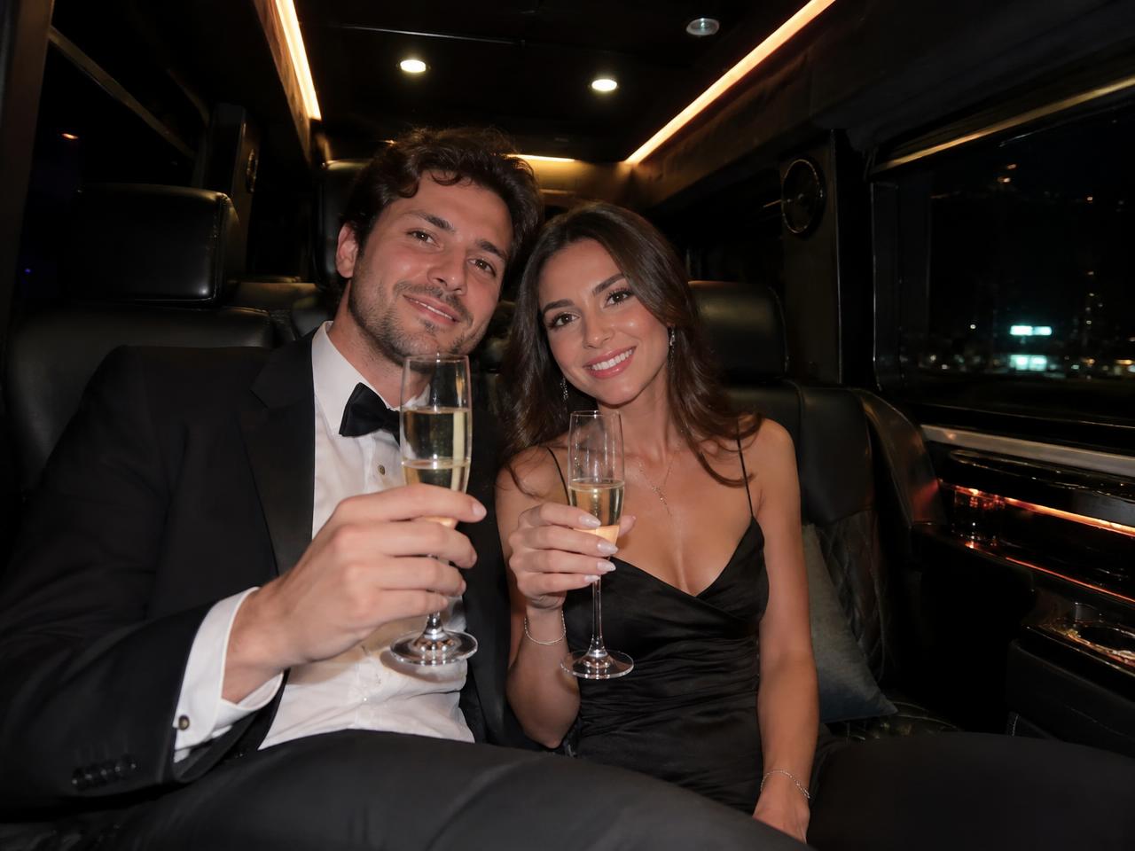 Couple toasting champagne inside the limo