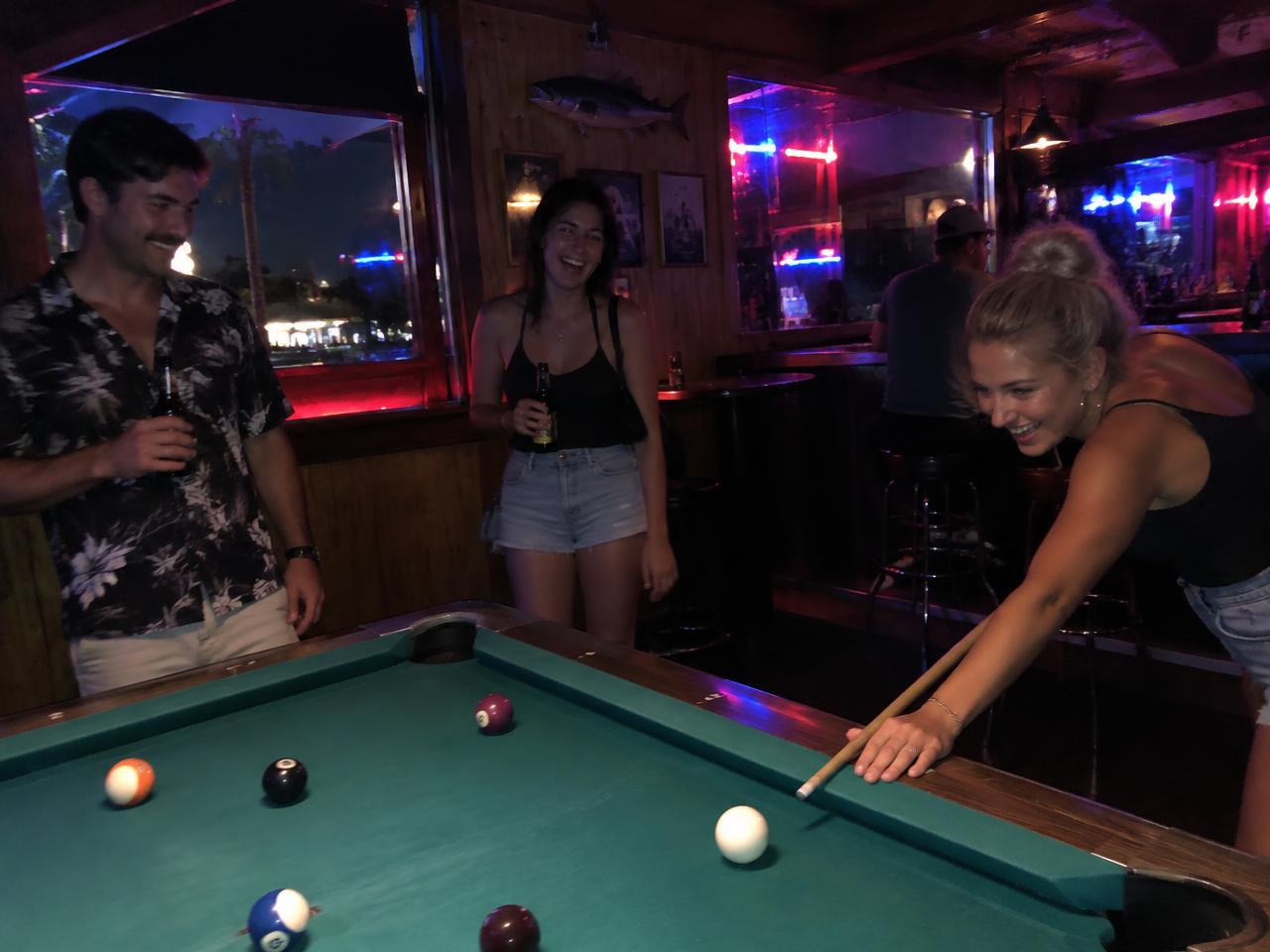 Friends playing pool at a St. Pete dive bar