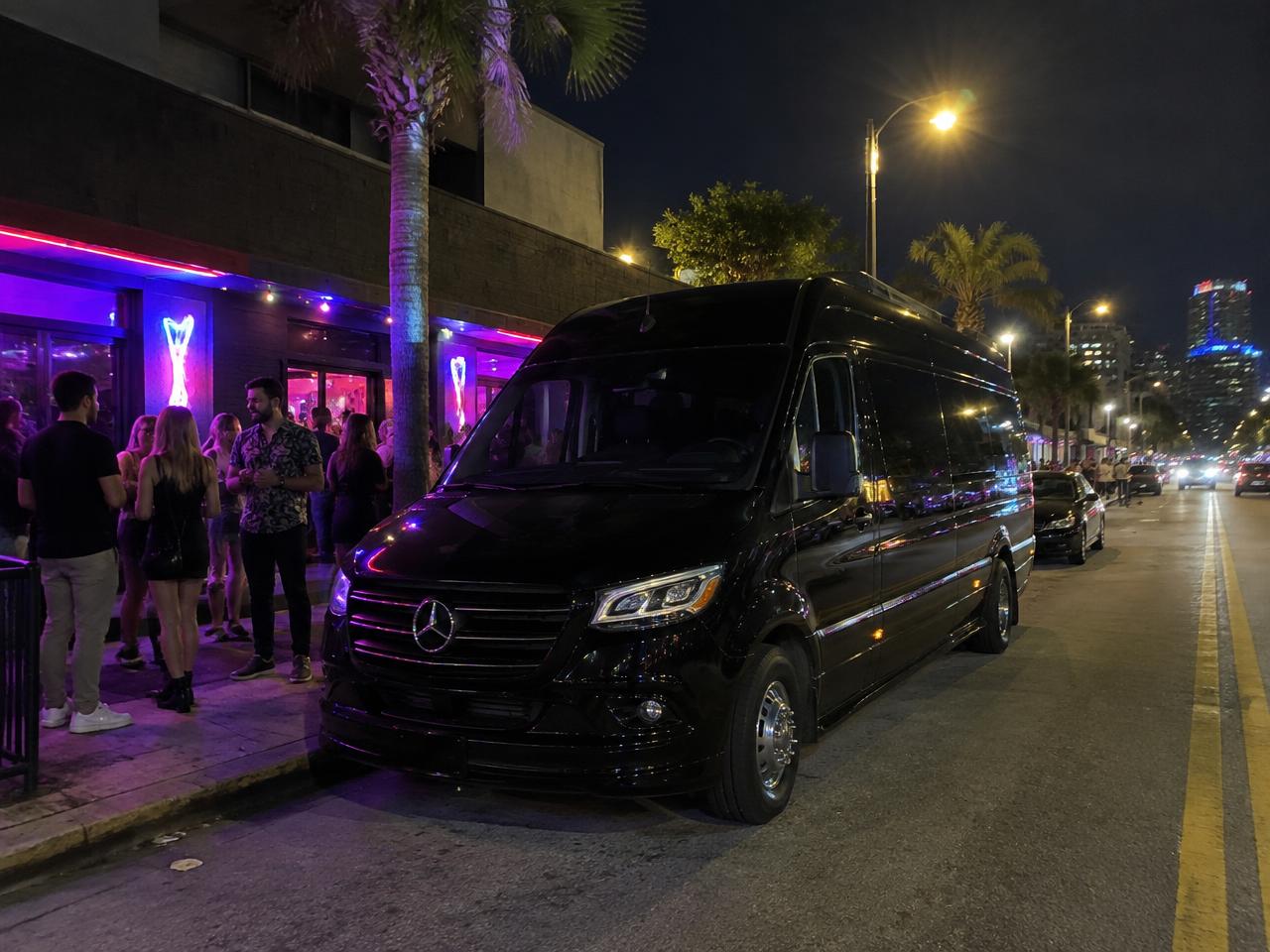 The Sprinter limo parked outside a neon-lit bar
