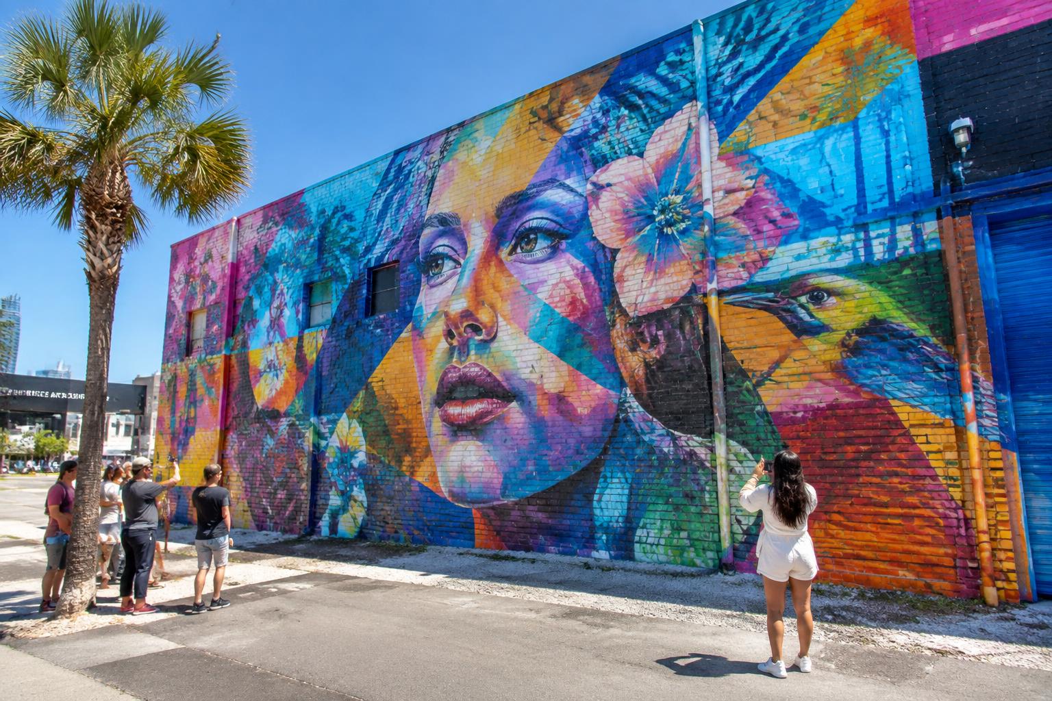 Guests photographing a giant portrait mural in the Warehouse Arts District
